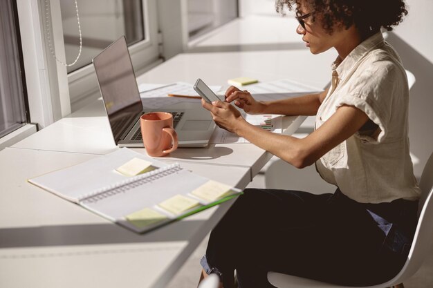 Foto homem a usar telemóvel no escritório