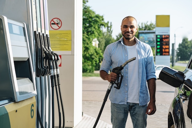 Foto homem abastecendo gasolina em carro em posto de gasolina