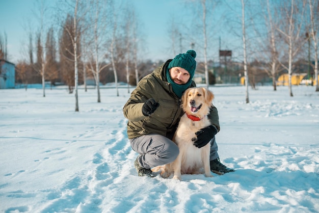 Homem abraça com um cachorro golden retriever ao ar livre