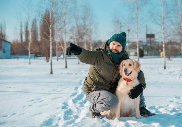 Foto homem abraça com um cachorro golden retriever ao ar livre