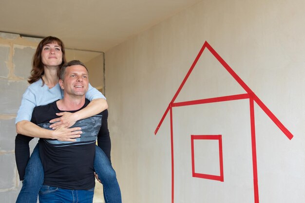 Homem abraçando sua esposa Jovem casal se mudando para novos apartamentos Vista lateral Conceito novas casas novo começo