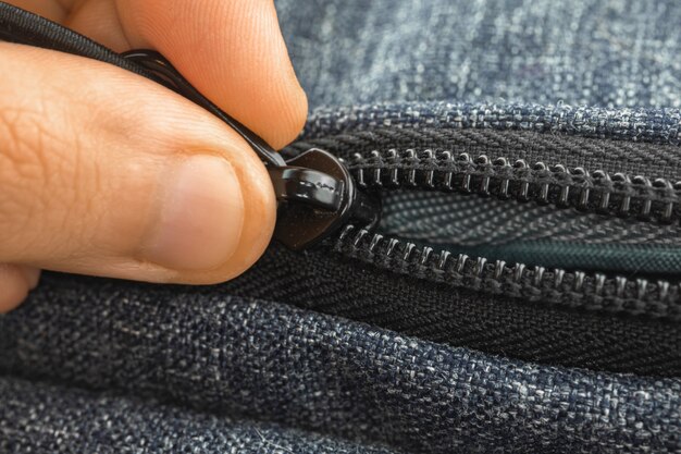 Foto homem abre bolsa com zíper, zíper de metal e foto de close-up com os dedos