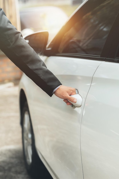 Homem abrindo as portas do carro para dirigir para o trabalho usando veículos para viajar com segurança na estrada e respeitando as regras de trânsito conceito de condução de segurança