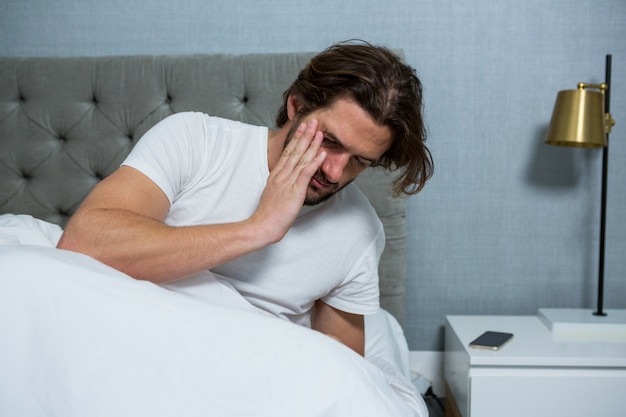 Homem acordando do sono no quarto