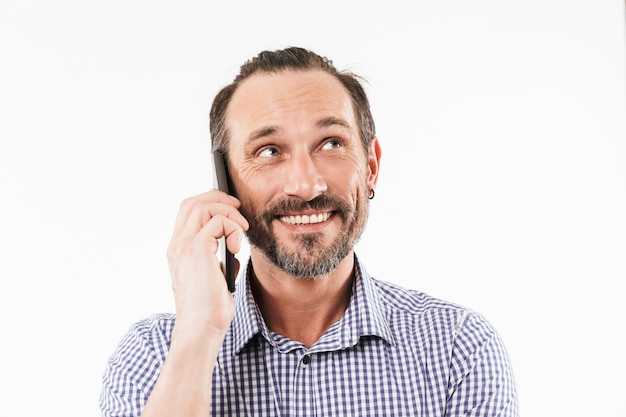 Homem adulto alegre falando pelo telefone móvel.