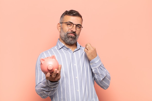 Homem adulto bonito parecendo arrogante, bem-sucedido, positivo e orgulhoso, apontando para si mesmo