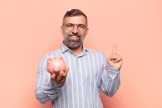 Homem adulto bonito sorrindo feliz e apontando para o lado e para cima com as duas mãos mostrando o objeto no espaço da cópia