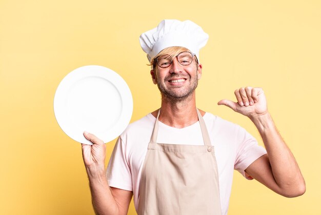 Homem adulto chef bonito loiro com um prato vazio