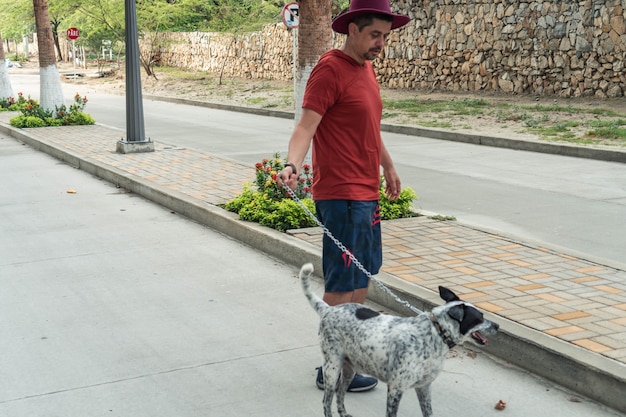 Homem adulto com cachorro nas mãos na vizinhança