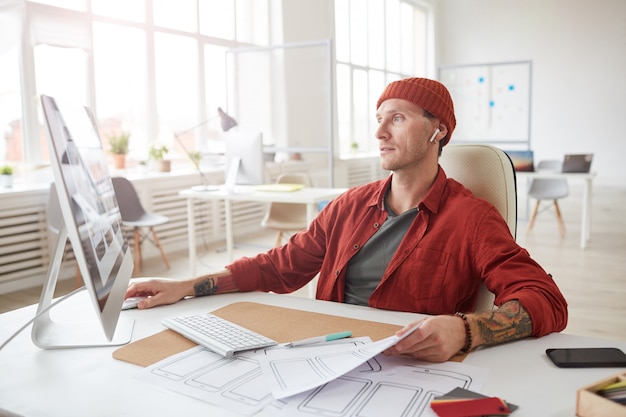 Homem adulto contemporâneo, trabalhando na mesa no escritório