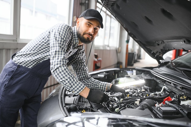Homem adulto em uniforme de cor azul trabalha no salão do automóvel