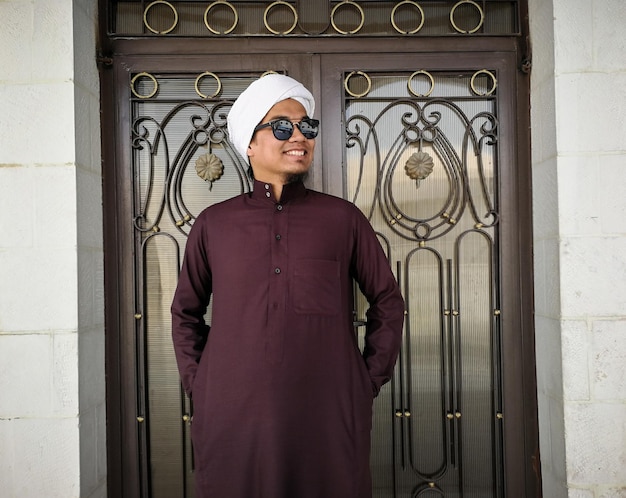 Foto homem adulto médio vestindo roupas tradicionais por uma porta fechada