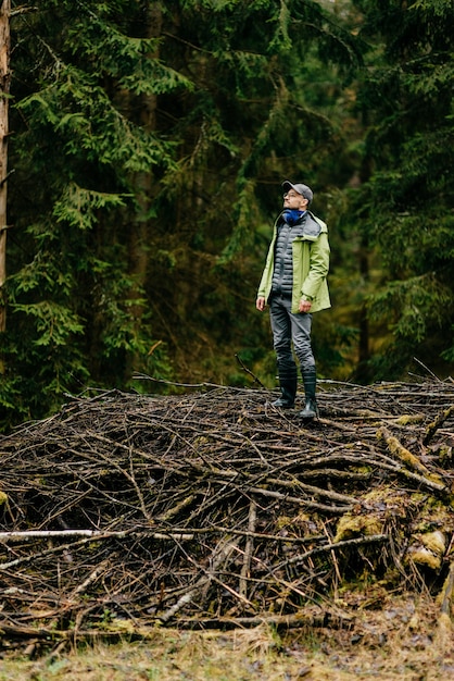 Homem adulto posando em gravetos na floresta