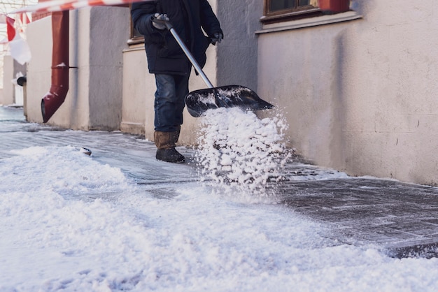 Homem adulto retirando neve das ruas da cidade