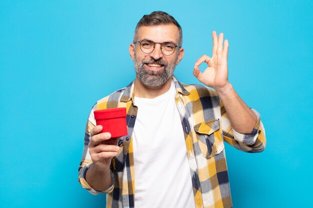 Homem adulto se sentindo feliz, relaxado e satisfeito, mostrando aprovação com gesto bem, sorrindo