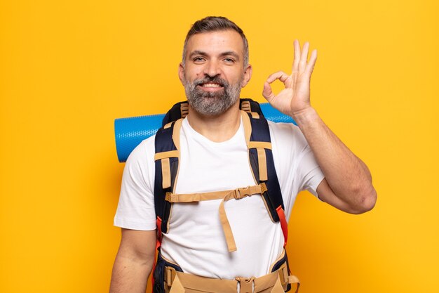 Homem adulto se sentindo feliz, relaxado e satisfeito, mostrando aprovação com gesto de ok, sorrindo