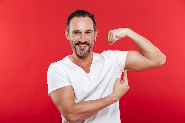 Homem adulto sorridente, mostrando o bíceps.