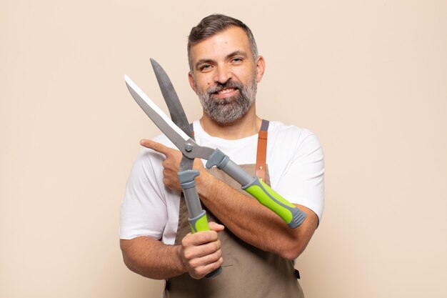 Homem adulto sorrindo alegremente, sentindo-se feliz e apontando para o lado e para cima, mostrando o objeto no espaço da cópia