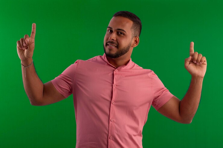 Foto homem adulto usando barba pequena com camisa cor de salmão em estúdio com fundo verde