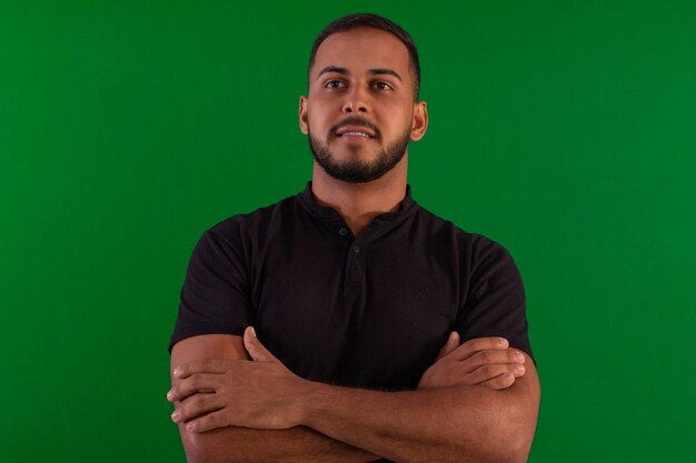 Foto homem adulto vestindo barba pequena com camisa preta em estúdio filmado com fundo verde