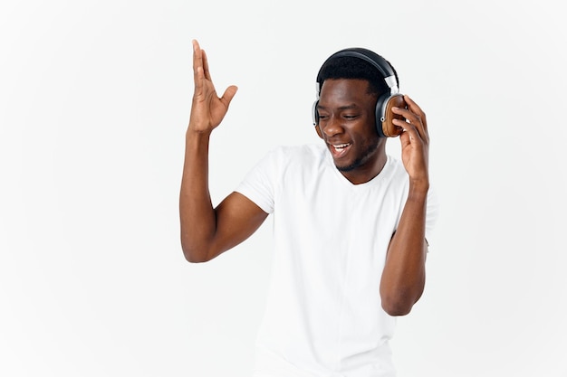 Homem africano alegre usando fones de ouvido gesto mãos emoções música entretenimento