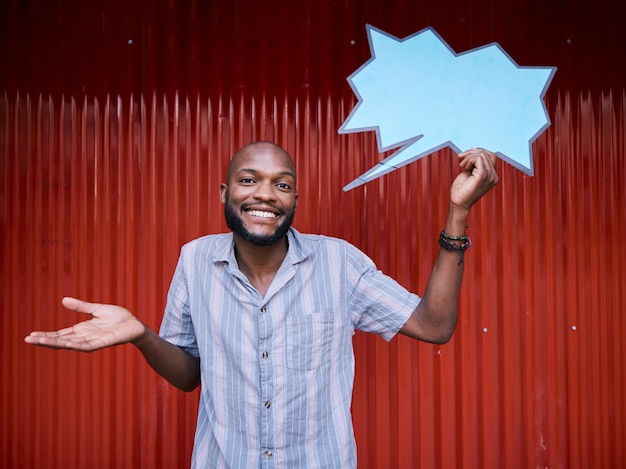 Homem africano ao ar livre e bolha de fala em dúvida de retrato ou promoção com espaço de maquete nas mídias sociais Estudante gen z cara e sorriso inseguro com outdoor de cartaz em branco ou apresentação para feedback