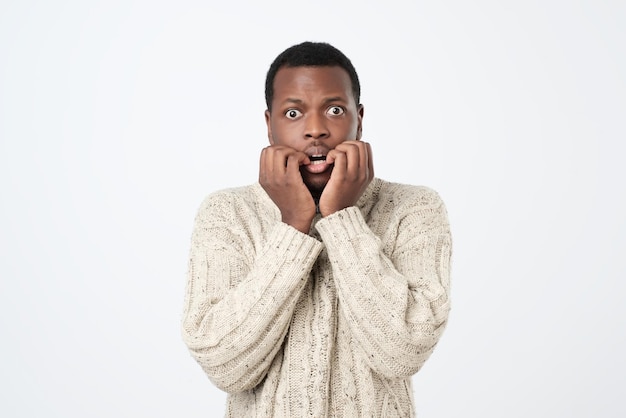 Homem africano com expressão nervosa morde unhas de dedo preocupações antes da entrevista