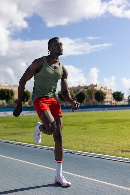 Homem africano correndo na pista de atletismo