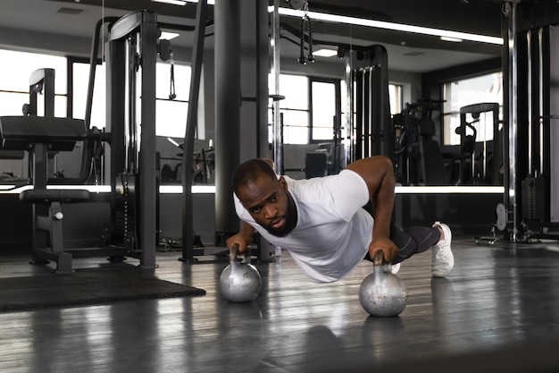 Homem africano desportivo fazendo flexão em uma academia