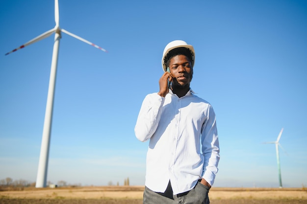 Homem africano engenheiro em pé com turbina eólica