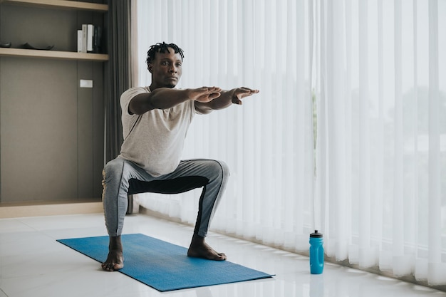 Homem africano fazendo exercício de agachamento