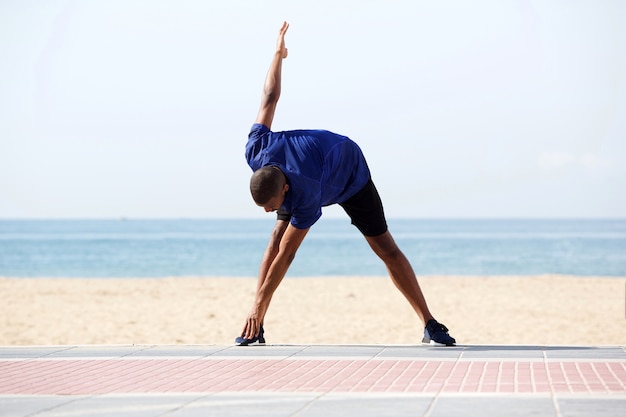 Homem Africano fazendo exercício de manhã na praia