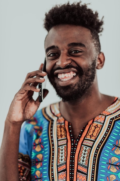 Homem africano nativo do Sudão usando smartphone isolado no fundo branco. Foto de alta qualidade