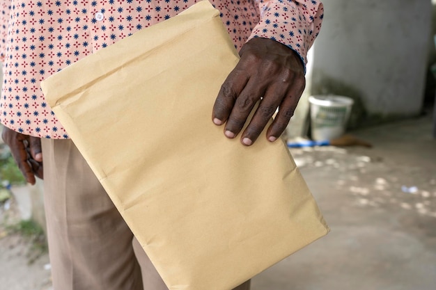 Homem africano segurando um saco de papel na mão com documentos ilha Zanzibar Tanzânia África fechar