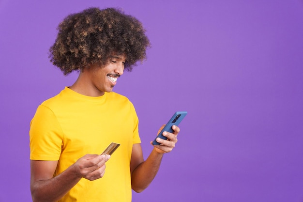 Foto homem africano usando o celular e cartão para fazer compras online