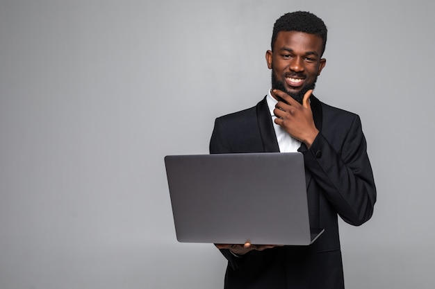 Homem afro-americano alegre segurando laptop com tela em branco