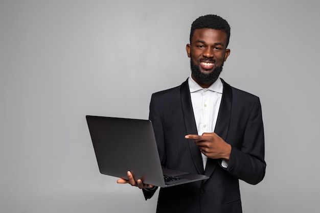 Homem afro-americano alegre segurando laptop com tela em branco