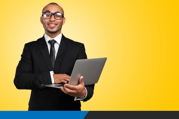 Homem afro-americano bonito com um laptop