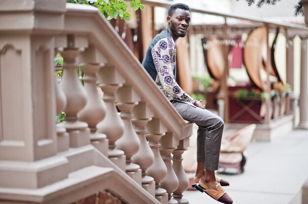 Homem afro-americano bonito vestindo roupas tradicionais na cidade moderna.