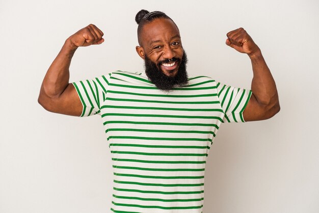 Homem afro-americano com barba isolada em fundo rosa, mostrando força gesto com os braços, símbolo do poder feminino