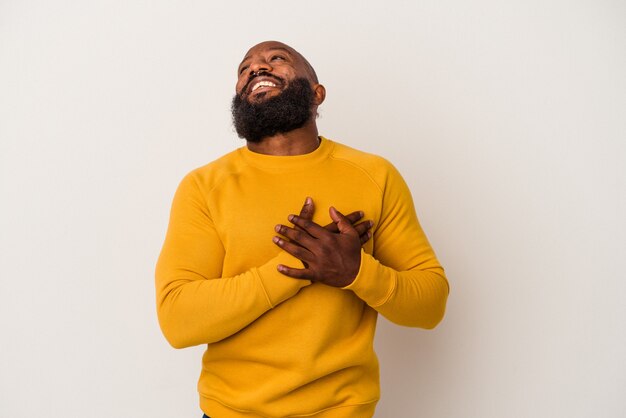 Homem afro-americano com barba isolada no fundo rosa rindo mantendo as mãos no coração, o conceito de felicidade.