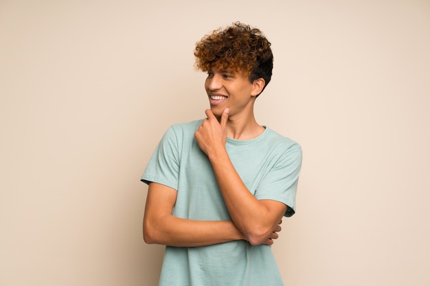 Homem afro-americano com camisa verde, olhando para o lado