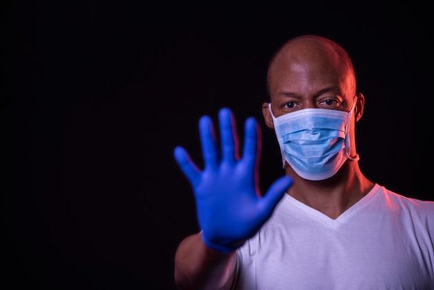 Foto homem afro-americano, com, máscara, mostrando, sinal parada, coronavirus