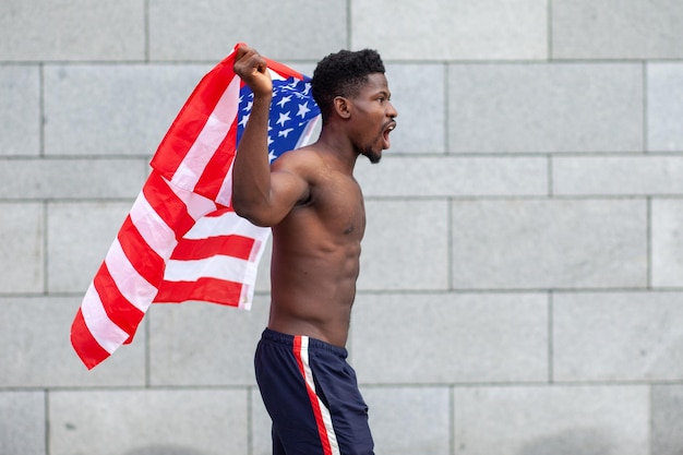Homem afro-americano com protestos de bandeira dos eua e gritos mostrando agressão na rua