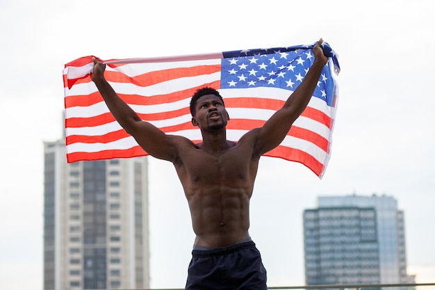 Homem afro-americano com protestos de bandeira dos eua e gritos mostrando agressão na rua