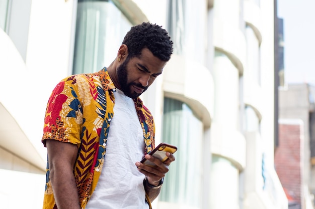 Homem afro-americano com um smartphone na rua