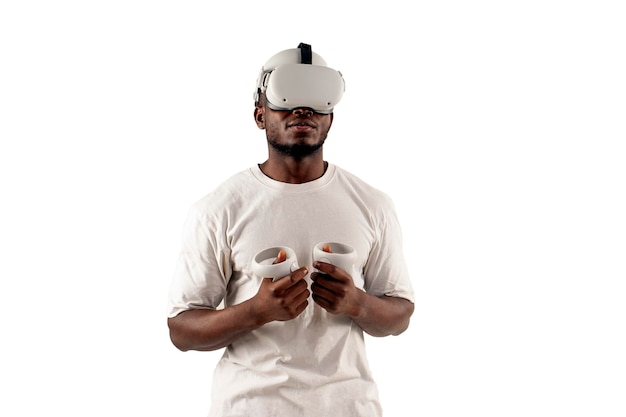 Homem afro-americano de camisa branca em óculos de realidade virtual segura joysticks em fundo branco