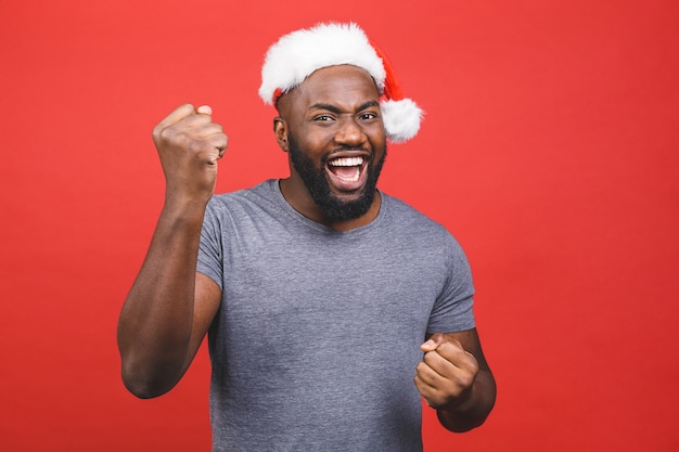 Homem afro-americano de camiseta cinza e chapéu de Papai Noel