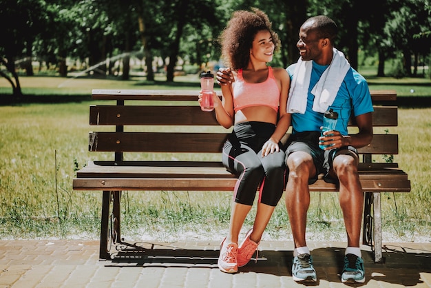 Homem afro-americano e linda garota no banco do parque.