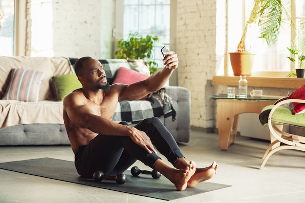 Foto homem afro-americano ensinando em casa cursos on-line de fitness aeróbio estilo de vida esportivo